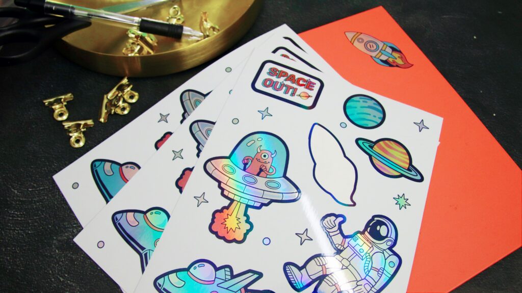 Colorful space-themed holographic stickers on desk