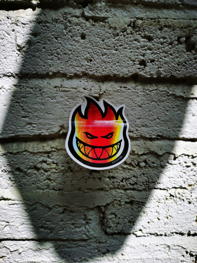Flaming face sticker on textured brick wall
