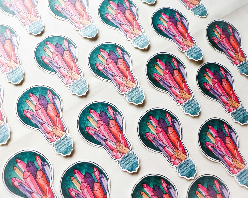 Colorful crystal light bulb stickers on white background