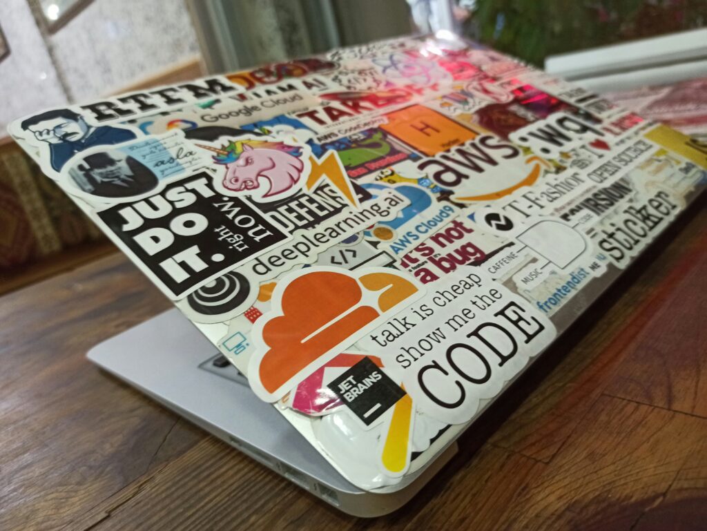 Laptop covered with colorful programming and tech stickers