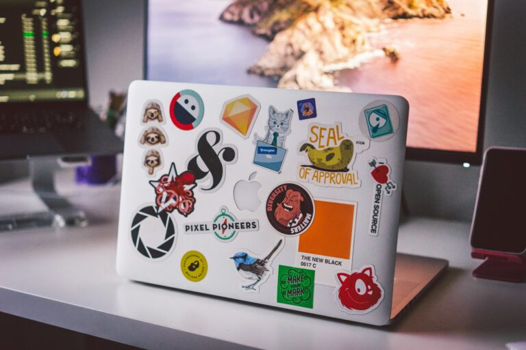 Laptop covered with colorful stickers on desk